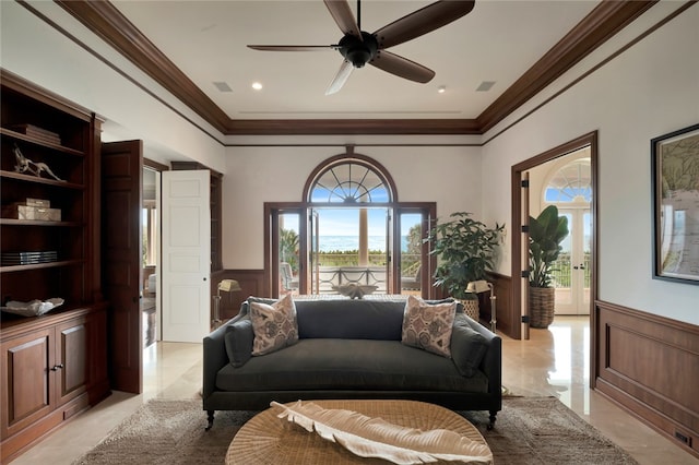 sitting room with ceiling fan, built in shelves, and ornamental molding