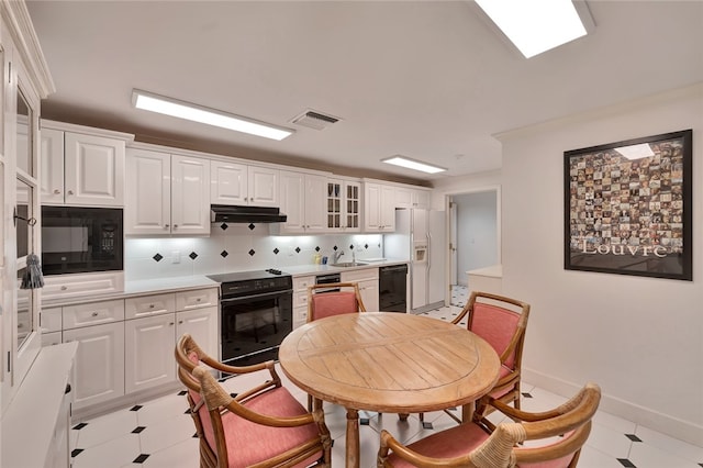 kitchen with white cabinetry, sink, black appliances, and decorative backsplash