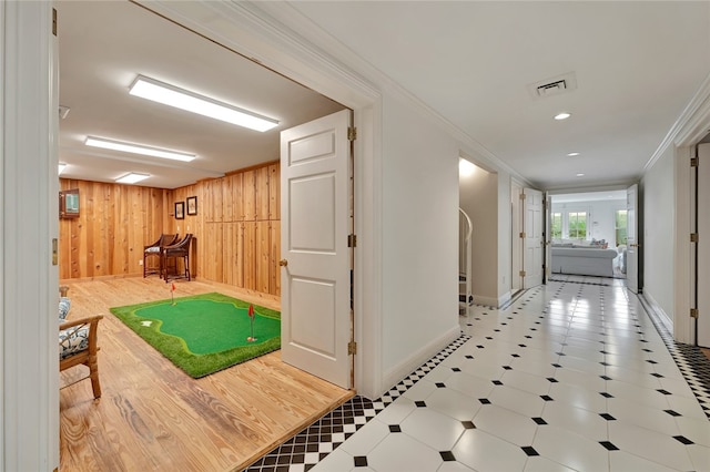 hallway featuring wood walls and ornamental molding