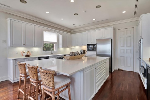 600 Ocean Rd, Vero Beach, FL 32963 - kitchen with a sink, stainless steel refrigerator, dark wood-type flooring, a kitchen island with sink, and light countertops