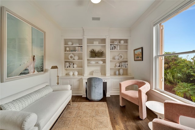 living area with dark wood-type flooring, a wealth of natural light, and crown molding