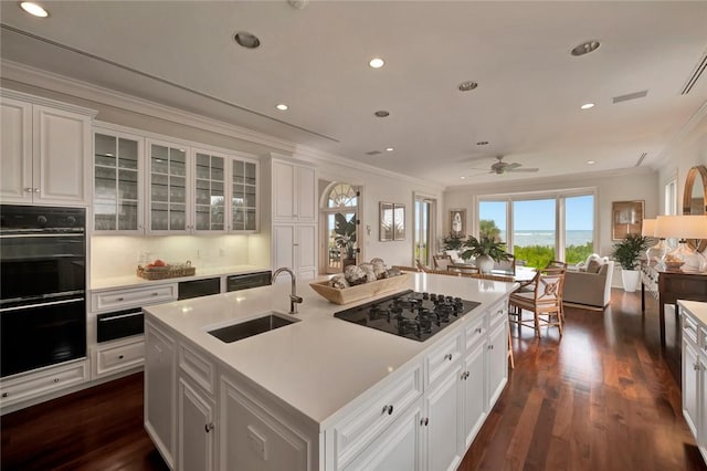 600 Ocean Rd, Vero Beach, FL 32963 - kitchen featuring a sink, black appliances, ornamental molding, white cabinets, and dark wood finished floors