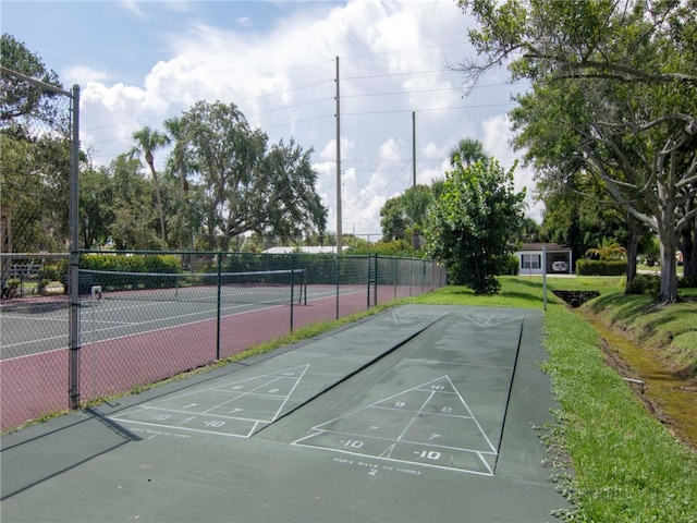 view of property's community featuring tennis court