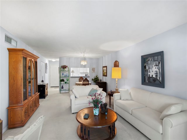 living room with a chandelier and light colored carpet