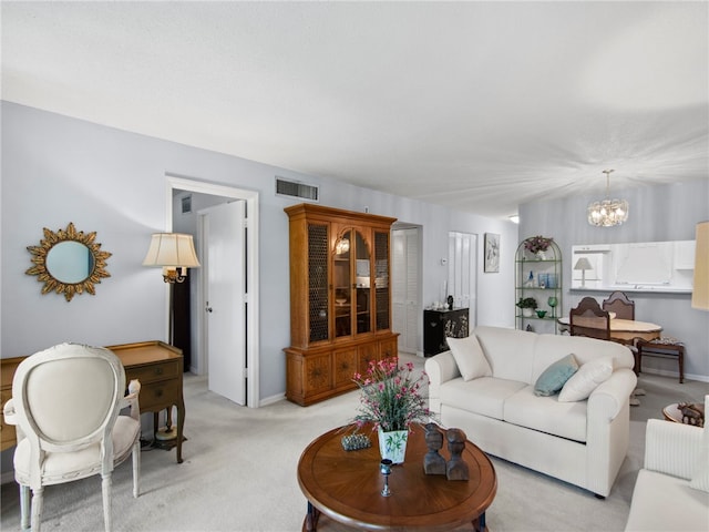 carpeted living room with a chandelier