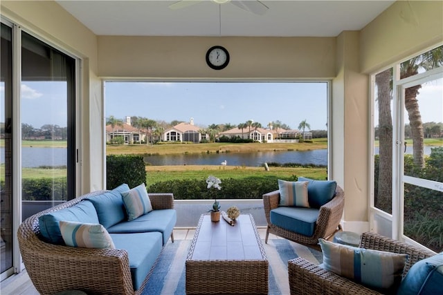 sunroom / solarium featuring ceiling fan, a healthy amount of sunlight, and a water view