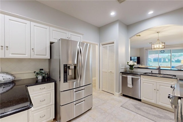 kitchen featuring light tile patterned flooring, sink, tasteful backsplash, appliances with stainless steel finishes, and white cabinets