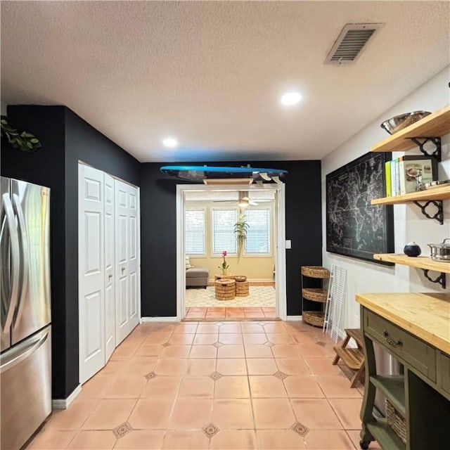 entryway featuring a textured ceiling and light tile patterned flooring