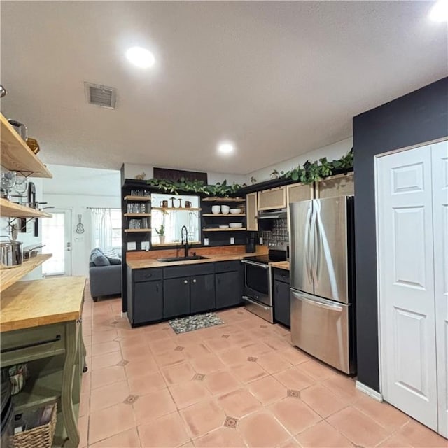 kitchen with appliances with stainless steel finishes, sink, and light tile patterned floors