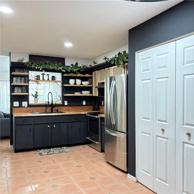 kitchen with stainless steel appliances, extractor fan, sink, and light tile patterned flooring