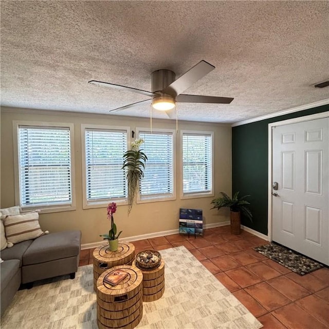 sitting room featuring tile patterned flooring, ceiling fan, ornamental molding, and a textured ceiling