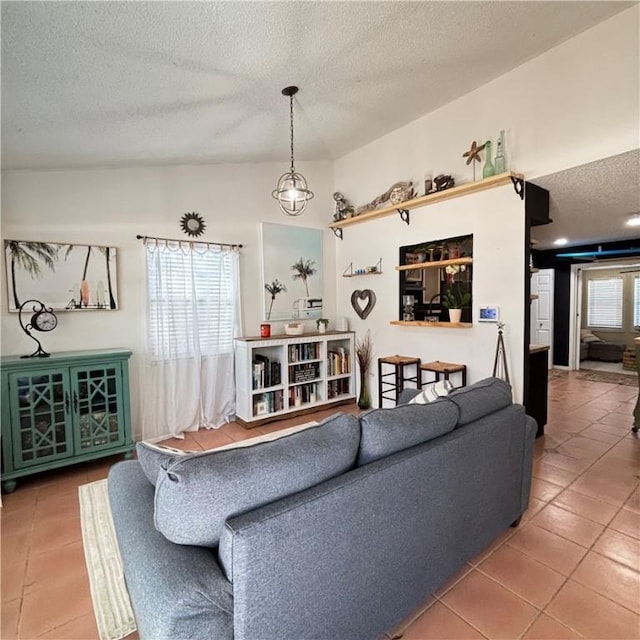 living room featuring tile patterned floors, vaulted ceiling, and a textured ceiling