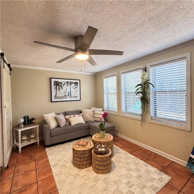 tiled living room with crown molding, a barn door, a textured ceiling, and ceiling fan