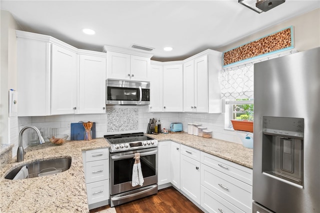 51 Woodland Dr Unit 106, Vero Beach, FL 32962 - kitchen featuring stainless steel appliances, white cabinetry, light stone countertops, decorative backsplash, and recessed lighting