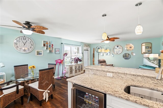 51 Woodland Dr Unit 106, Vero Beach, FL 32962 - kitchen with beverage cooler, a ceiling fan, dark wood-style floors, and light stone countertops
