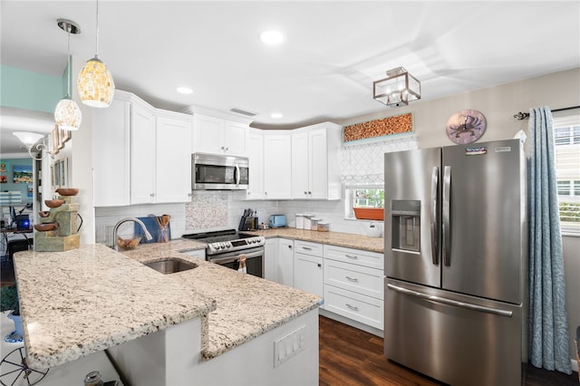 51 Woodland Dr Unit 106, Vero Beach, FL 32962 - kitchen with stainless steel appliances, a peninsula, tasteful backsplash, white cabinetry, and light stone countertops