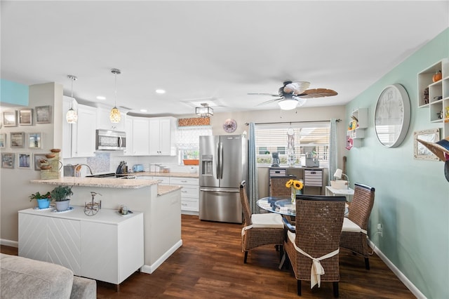 51 Woodland Dr Unit 106, Vero Beach, FL 32962 - kitchen with stainless steel appliances, a peninsula, a ceiling fan, white cabinetry, and dark wood-style flooring