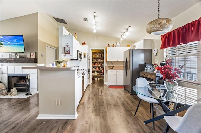 kitchen with visible vents, lofted ceiling, appliances with stainless steel finishes, wood finished floors, and white cabinetry