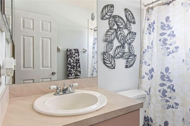 bathroom featuring curtained shower, vanity, and toilet