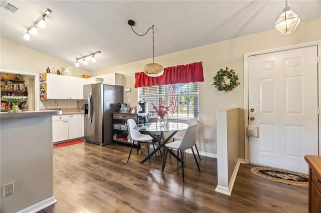 kitchen with lofted ceiling, dark wood-style flooring, visible vents, white cabinets, and stainless steel fridge with ice dispenser