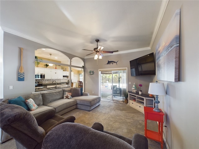 carpeted living room featuring sink, ornamental molding, and ceiling fan