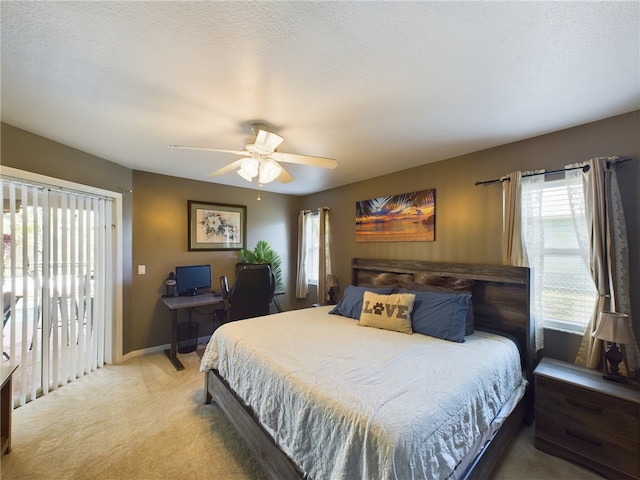 carpeted bedroom with a textured ceiling, access to exterior, and ceiling fan