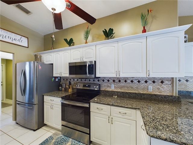 kitchen with white cabinetry, stainless steel appliances, decorative backsplash, and light tile patterned floors