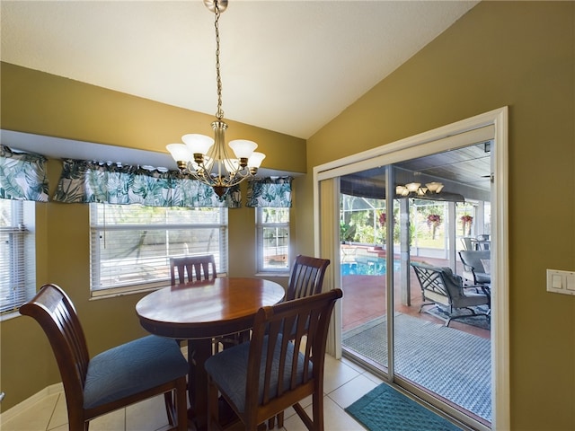 dining space with a notable chandelier, lofted ceiling, and light tile patterned floors