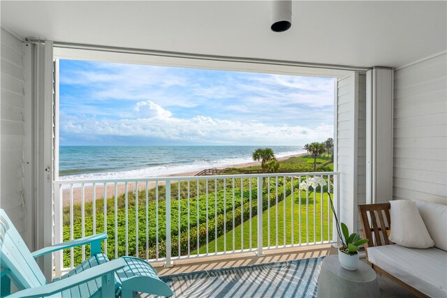 balcony featuring a water view and a view of the beach