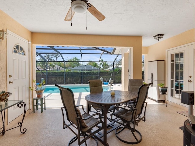 interior space featuring a lanai, a ceiling fan, and a fenced in pool