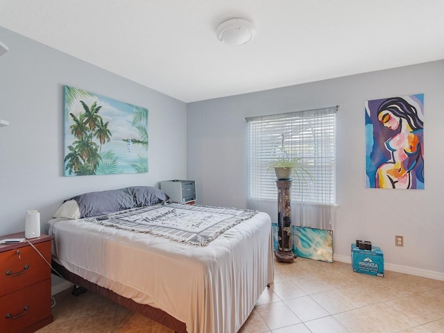 bedroom featuring light tile patterned floors and baseboards