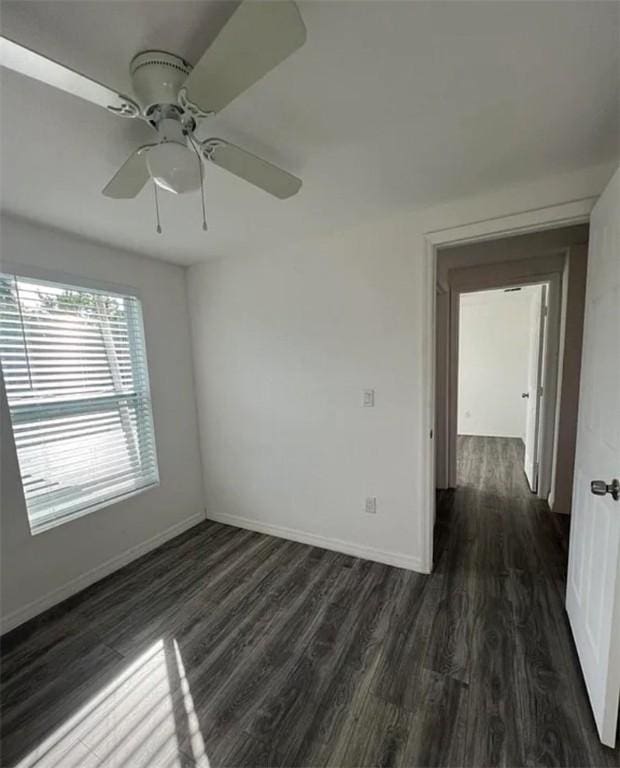 unfurnished room with ceiling fan and dark wood-type flooring