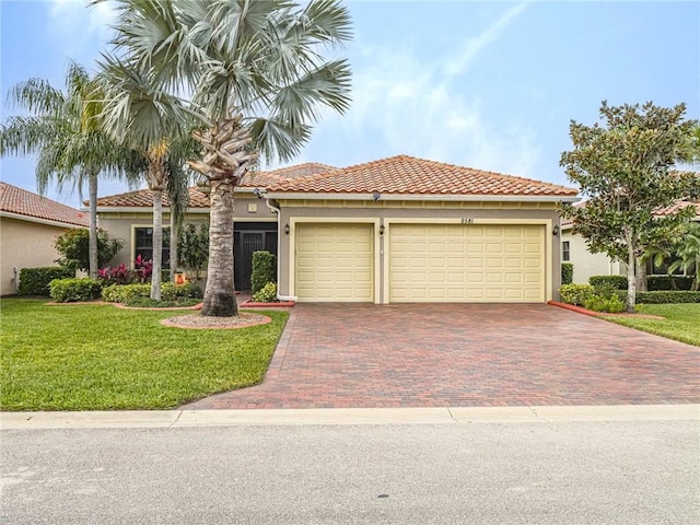 mediterranean / spanish-style house featuring a garage and a front lawn