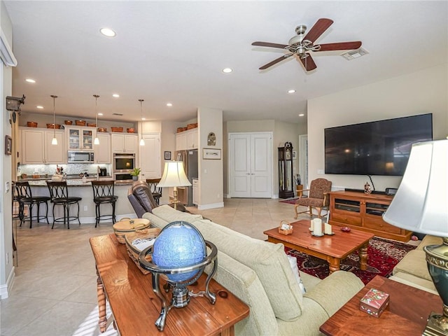 living room with ceiling fan and light tile patterned floors