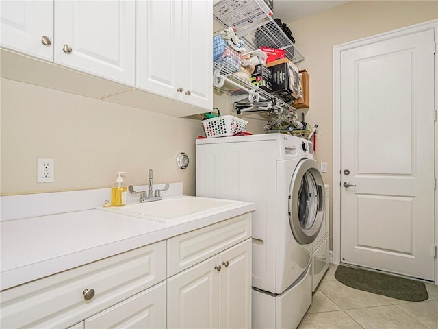 laundry room featuring washer and clothes dryer, sink, light tile patterned floors, and cabinets