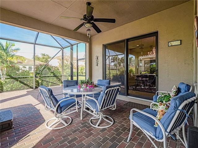 view of patio with glass enclosure and ceiling fan