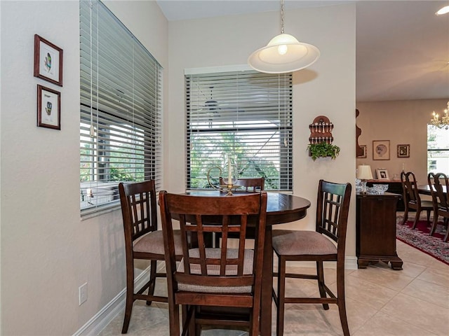 dining space with plenty of natural light, a notable chandelier, and light tile patterned flooring