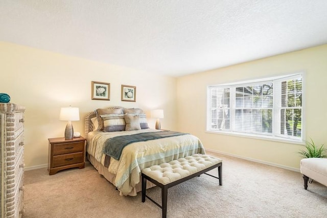 bedroom featuring light carpet, a textured ceiling, a brick fireplace, and baseboards