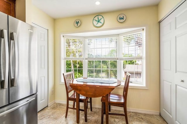 dining room featuring a healthy amount of sunlight and baseboards