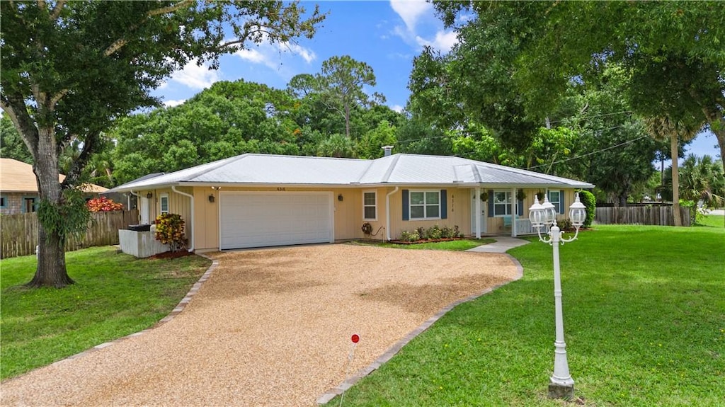 single story home featuring a front lawn, covered porch, and a garage