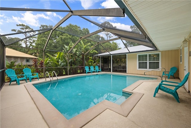 view of pool with glass enclosure and a patio area