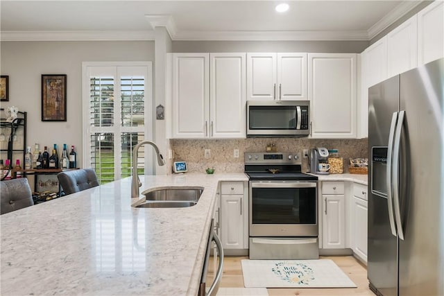 kitchen with appliances with stainless steel finishes, white cabinetry, and sink