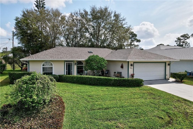 ranch-style house featuring an attached garage, driveway, a front lawn, and a shingled roof