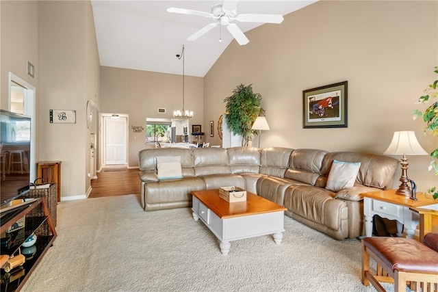 living room with high vaulted ceiling, light hardwood / wood-style floors, and ceiling fan with notable chandelier