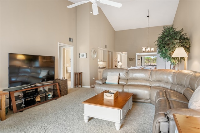 carpeted living room with ceiling fan with notable chandelier and high vaulted ceiling