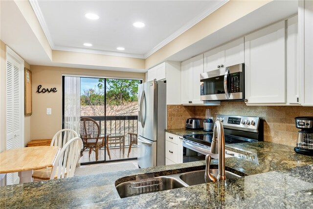 kitchen with white cabinetry, hardwood / wood-style flooring, appliances with stainless steel finishes, and dark stone counters