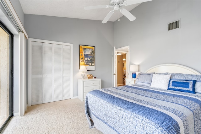 bedroom featuring high vaulted ceiling, a closet, light carpet, and ceiling fan