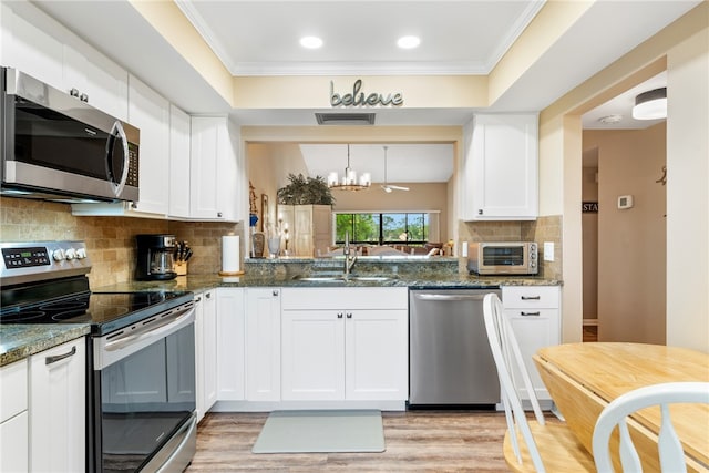 kitchen with white cabinets, sink, light wood-type flooring, and appliances with stainless steel finishes