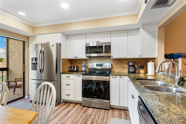 kitchen featuring dark stone countertops, appliances with stainless steel finishes, sink, and white cabinets