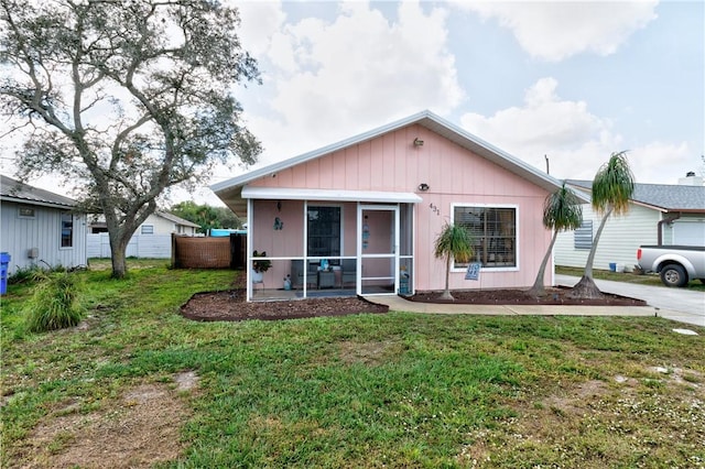 view of front of home with a sunroom and a front lawn